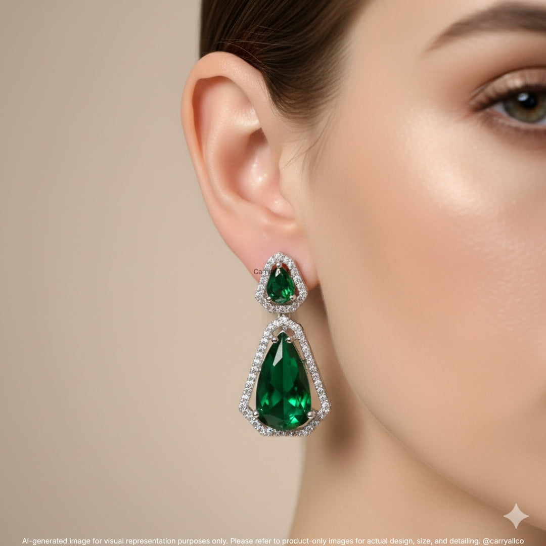 Close-up of a woman wearing a green teardrop earring with a beige background