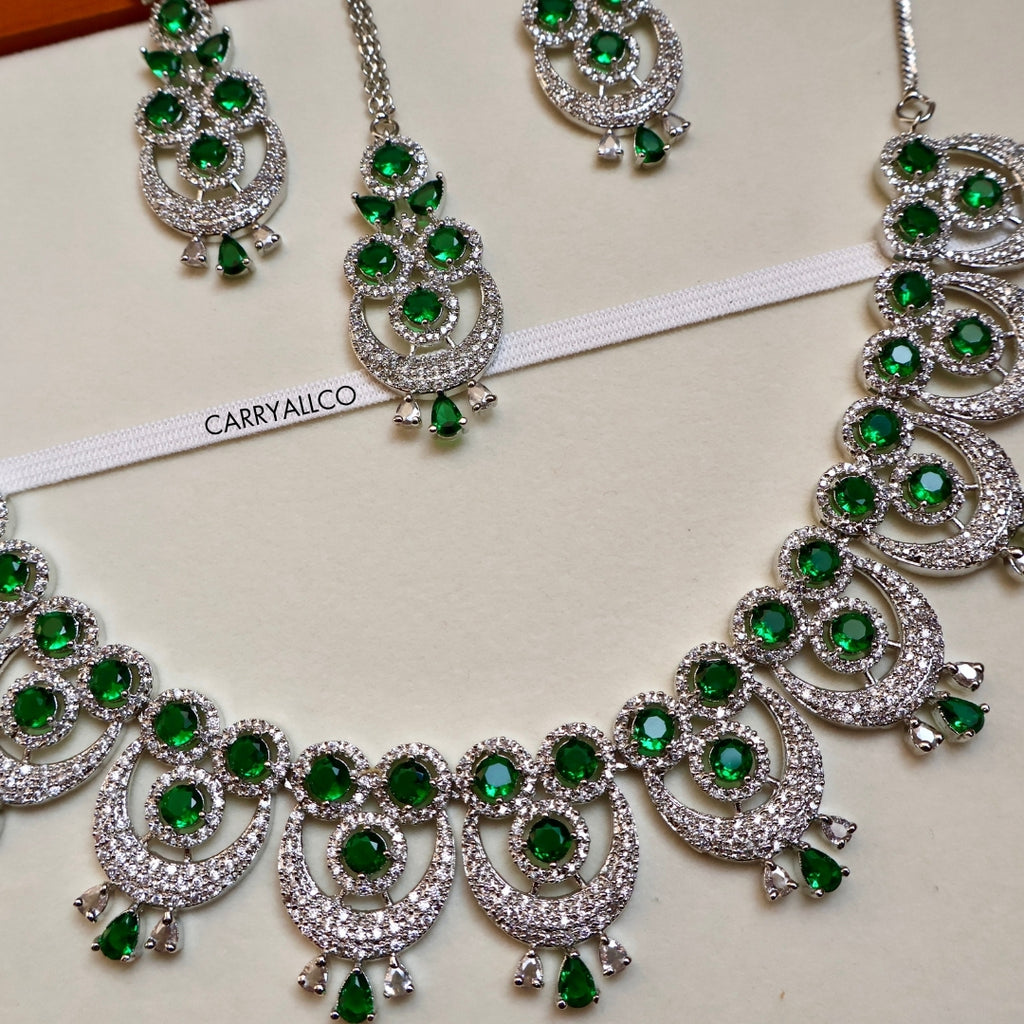 Ornate necklace with green gemstones and silver accents on a white background, featuring the brand 'CARRYALICO'.