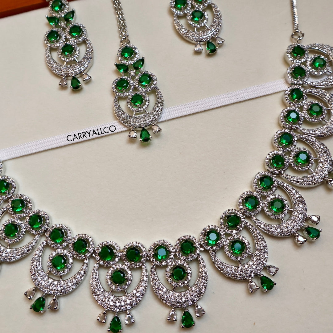 Ornate necklace with green gemstones and silver accents on a white background, featuring the brand 'CARRYALICO'.