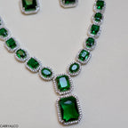 Necklace with green gemstones on a light gray background