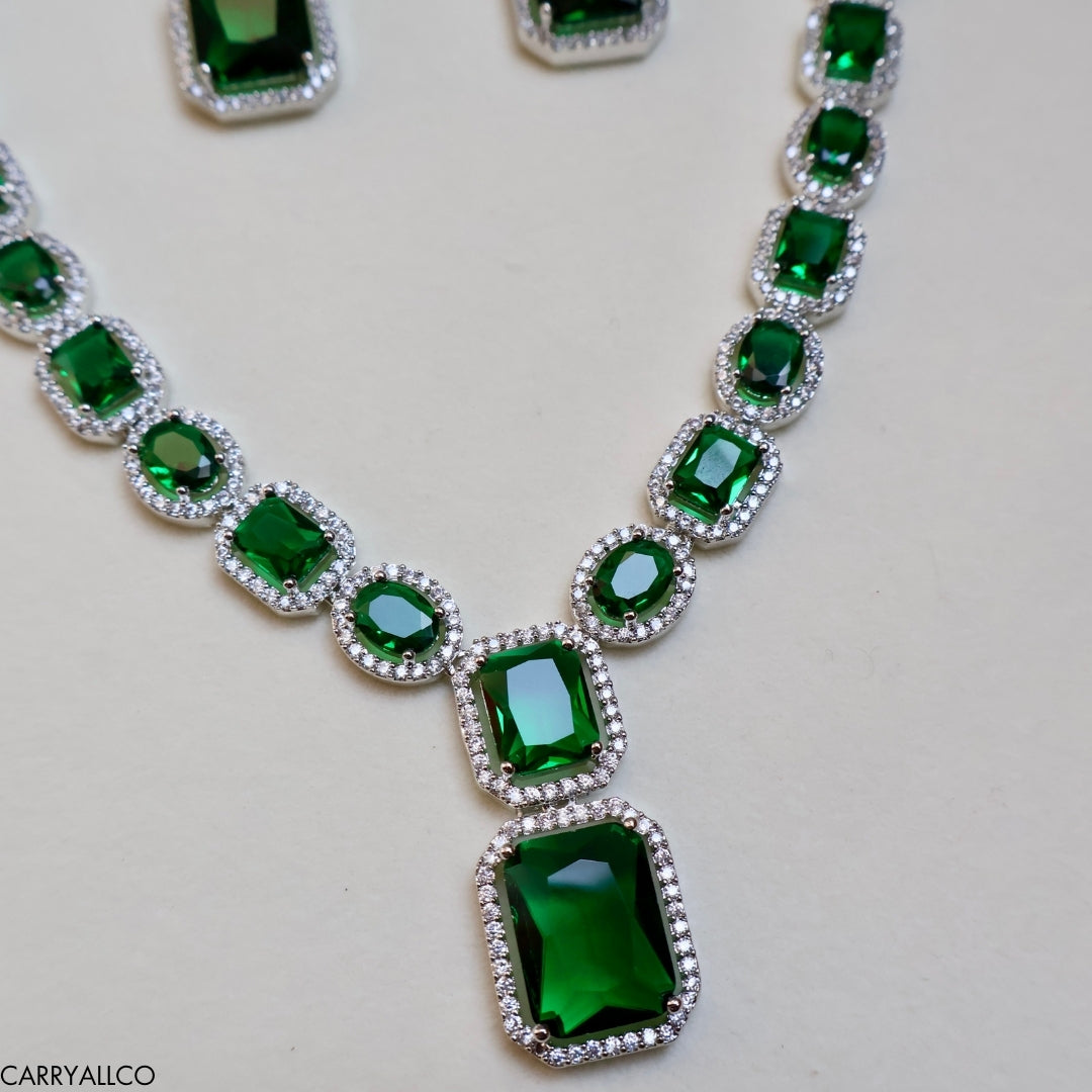 Necklace with green gemstones on a light gray background