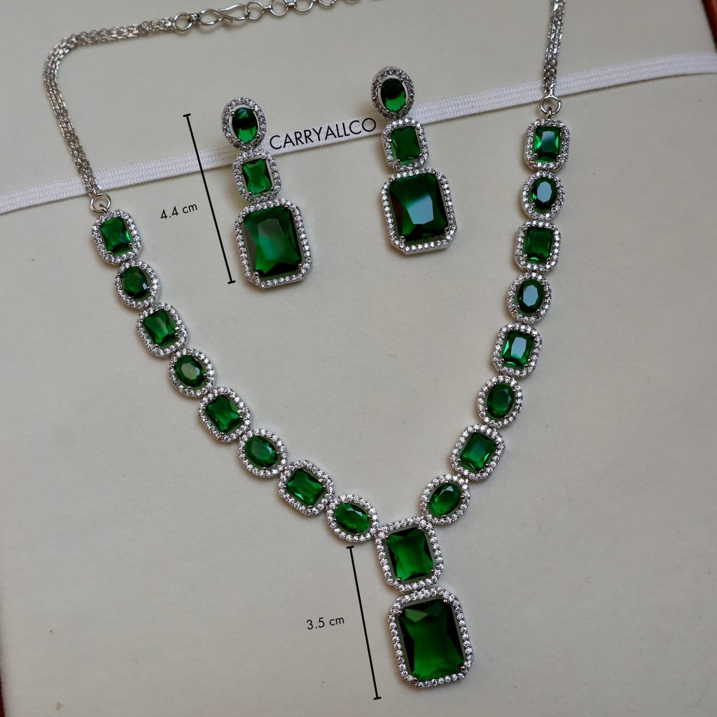 Jewelry set with green gemstones and silver accents on a white background