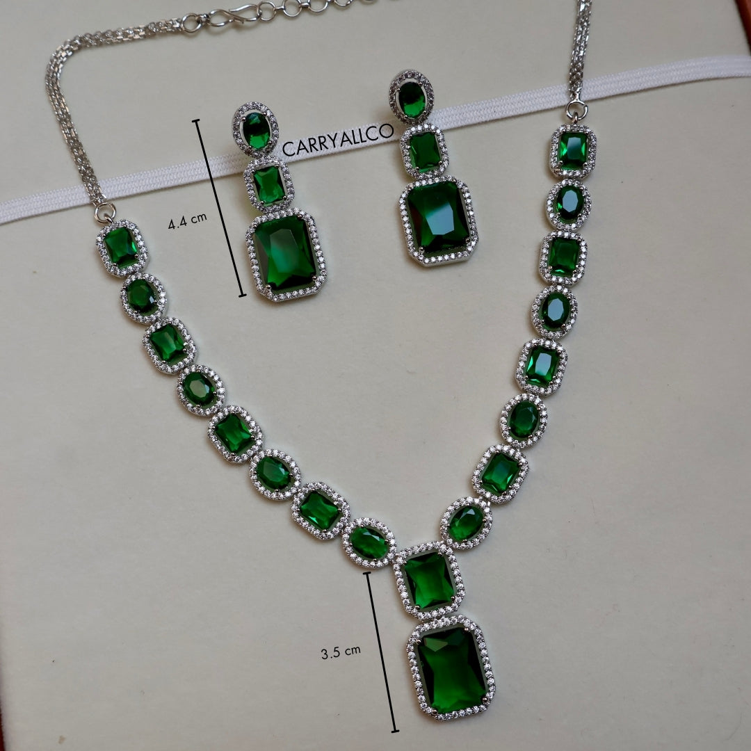 Jewelry set with green gemstones and silver accents on a white background