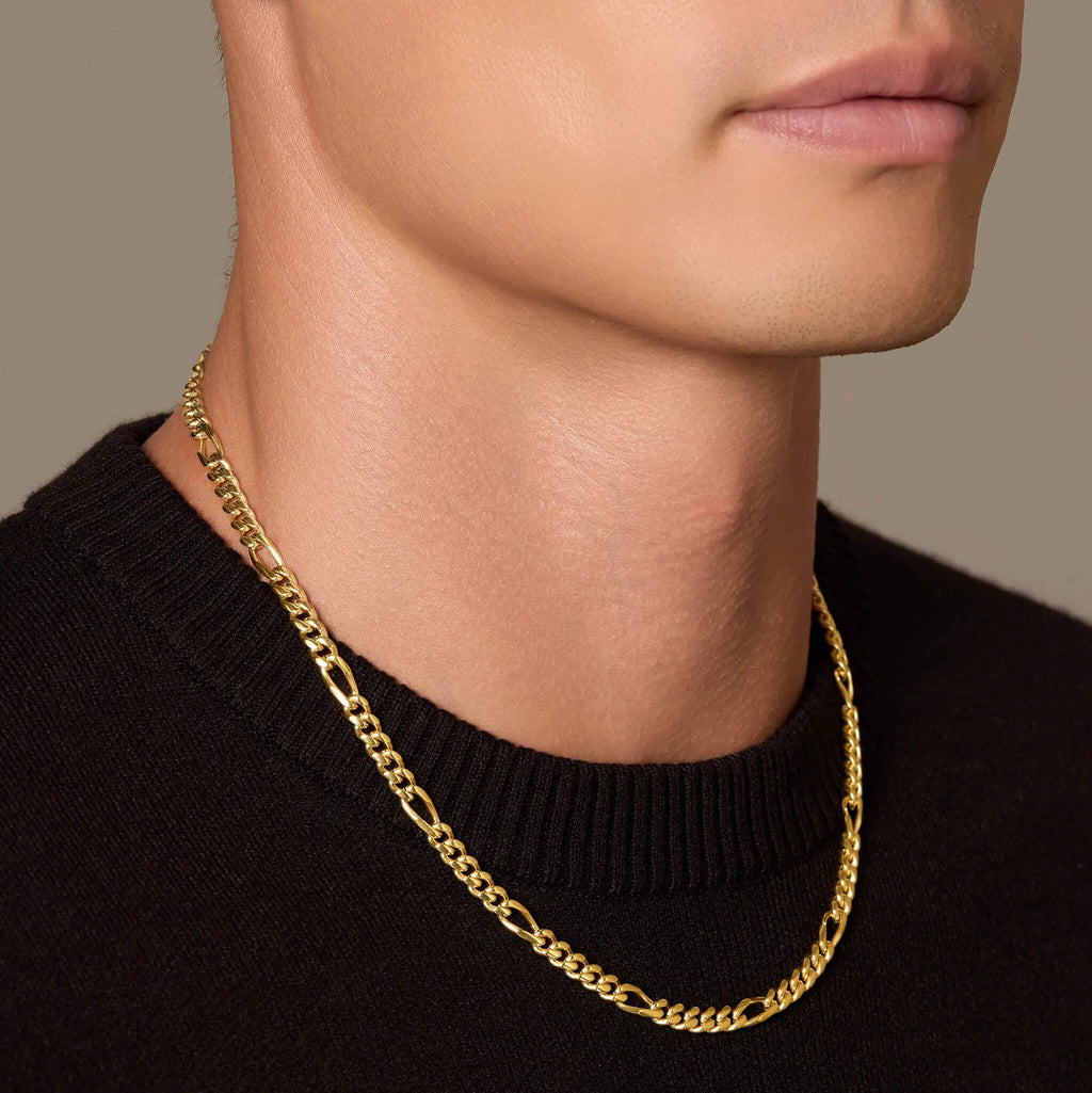 Gold chain necklace worn by a person against a neutral background