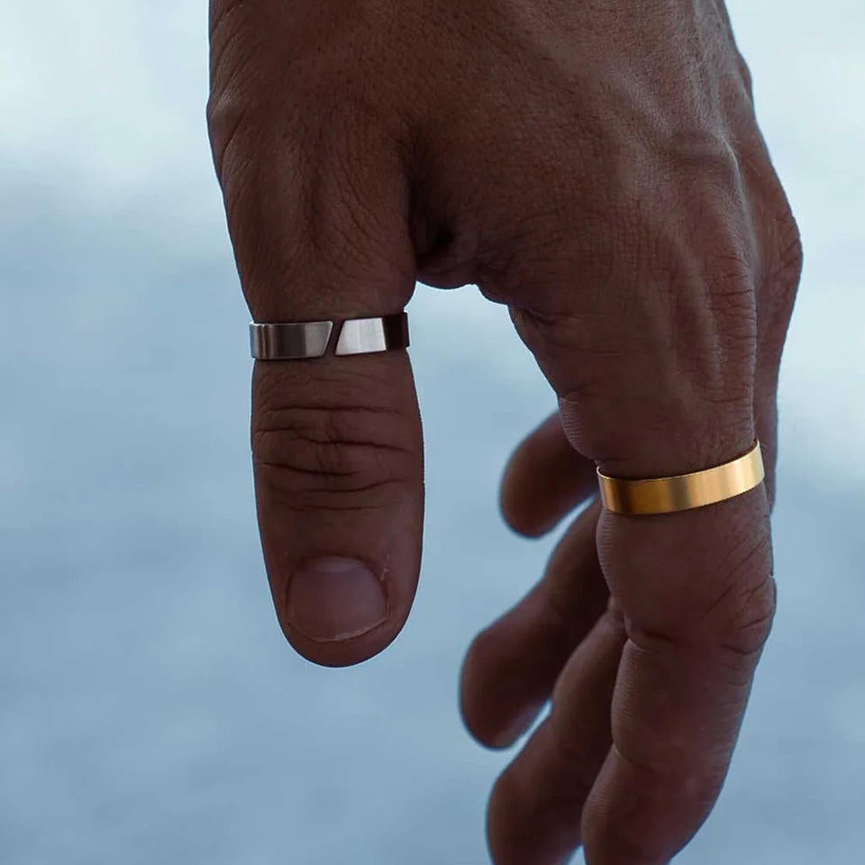 Close-up of a hand wearing two rings with a blurred background