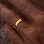 Gold ring on a person's finger with a blurred background