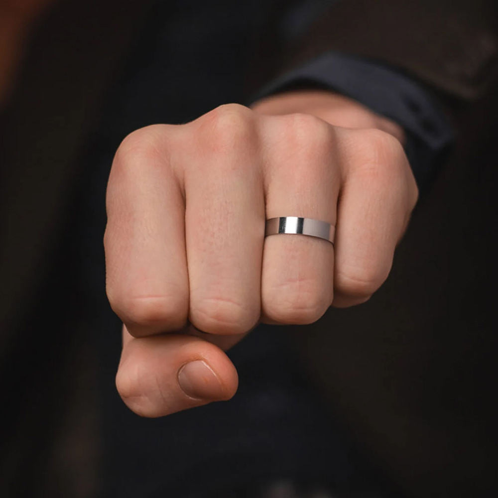 Fist wearing a silver ring against a dark background