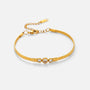 Gold bracelet with three circular charms on a light beige background