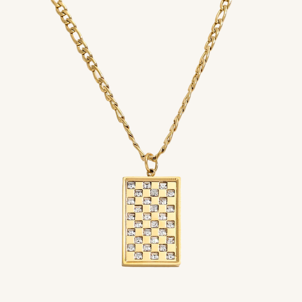 Gold necklace with a rectangular pendant featuring a checkered pattern on a white background
