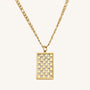 Gold necklace with a rectangular pendant featuring a checkered pattern on a white background