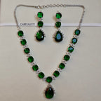 Green gemstone necklace and earrings set with 'CARRYALICO' branding on a light background