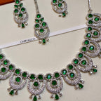 Ornate necklace with green gemstones and silver accents on a white background, featuring the brand 'CARRYALICO'.