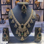 Ornate necklace set with green gemstones on a mannequin bust, with 'Mehendi polish Green' label.