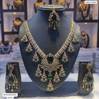 Ornate necklace set with green gemstones on a mannequin bust, with 'Mehendi polish Green' label.