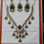 Ornate necklace with green gemstones on a white background
