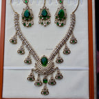 Ornate necklace with green gemstones on a white background