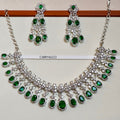 Necklace and earrings set with green gemstones on a white background