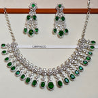 Necklace and earrings set with green gemstones on a white background