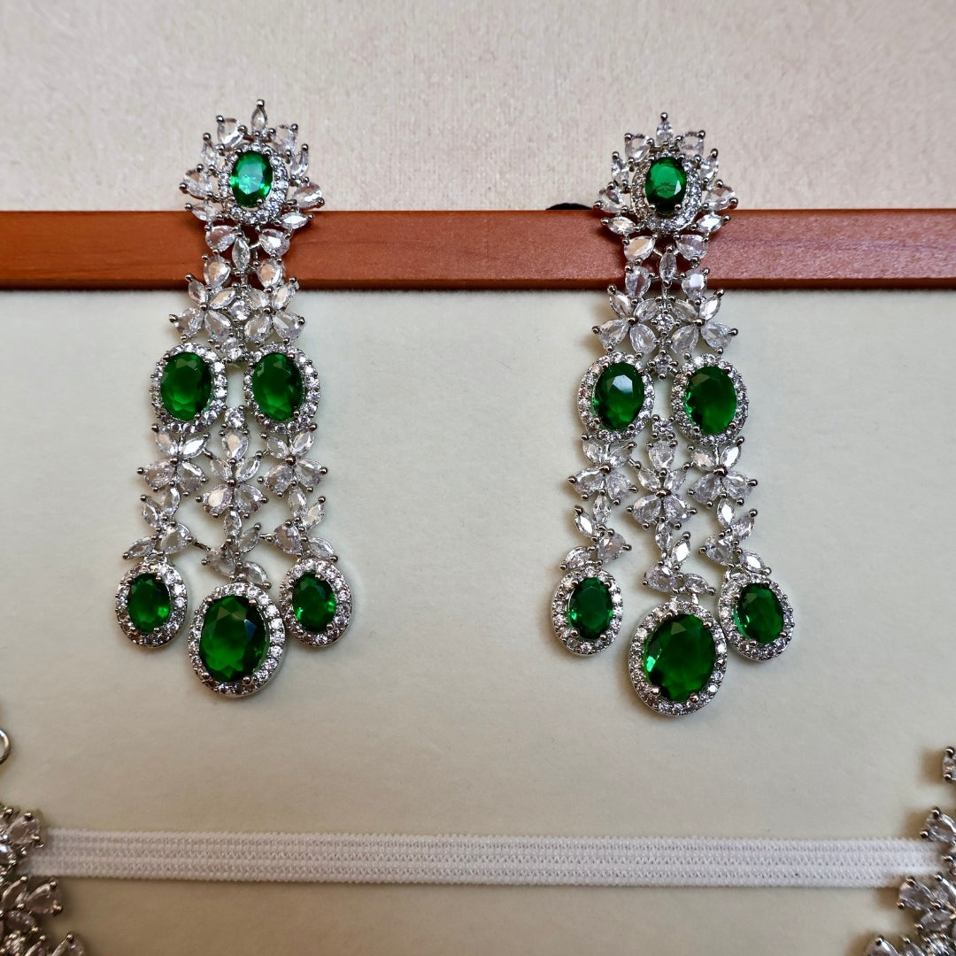 Pair of green gemstone earrings on a white background