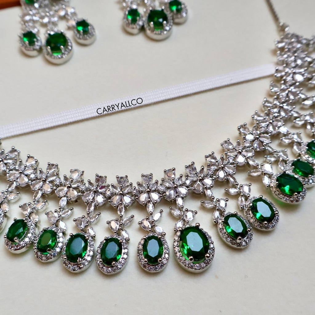 Jewelry set with green gemstones and silver accents on a white background, featuring the brand 'CARRYALLCO'.