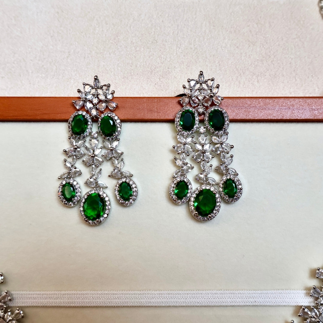 Pair of green gemstone earrings on a white background