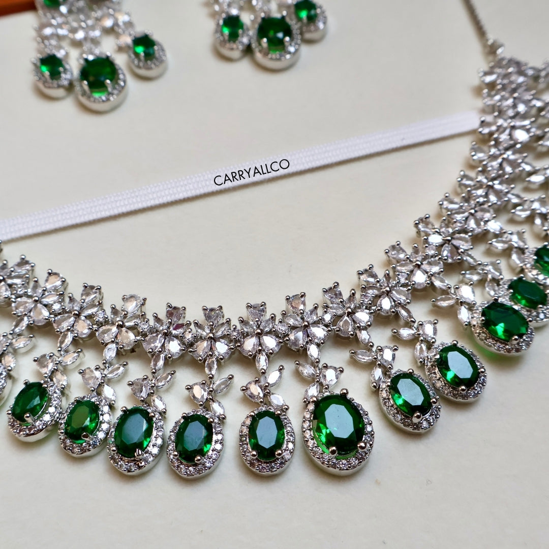 Jewelry set with green gemstones and silver accents on a white background, featuring the brand 'CARRYALCO'.