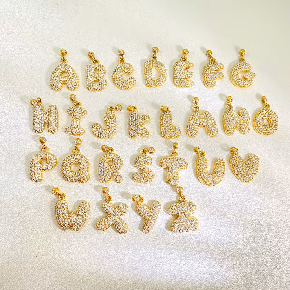 Gold letter pendants on a white background