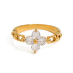Gold ring with diamond flower design on a white background