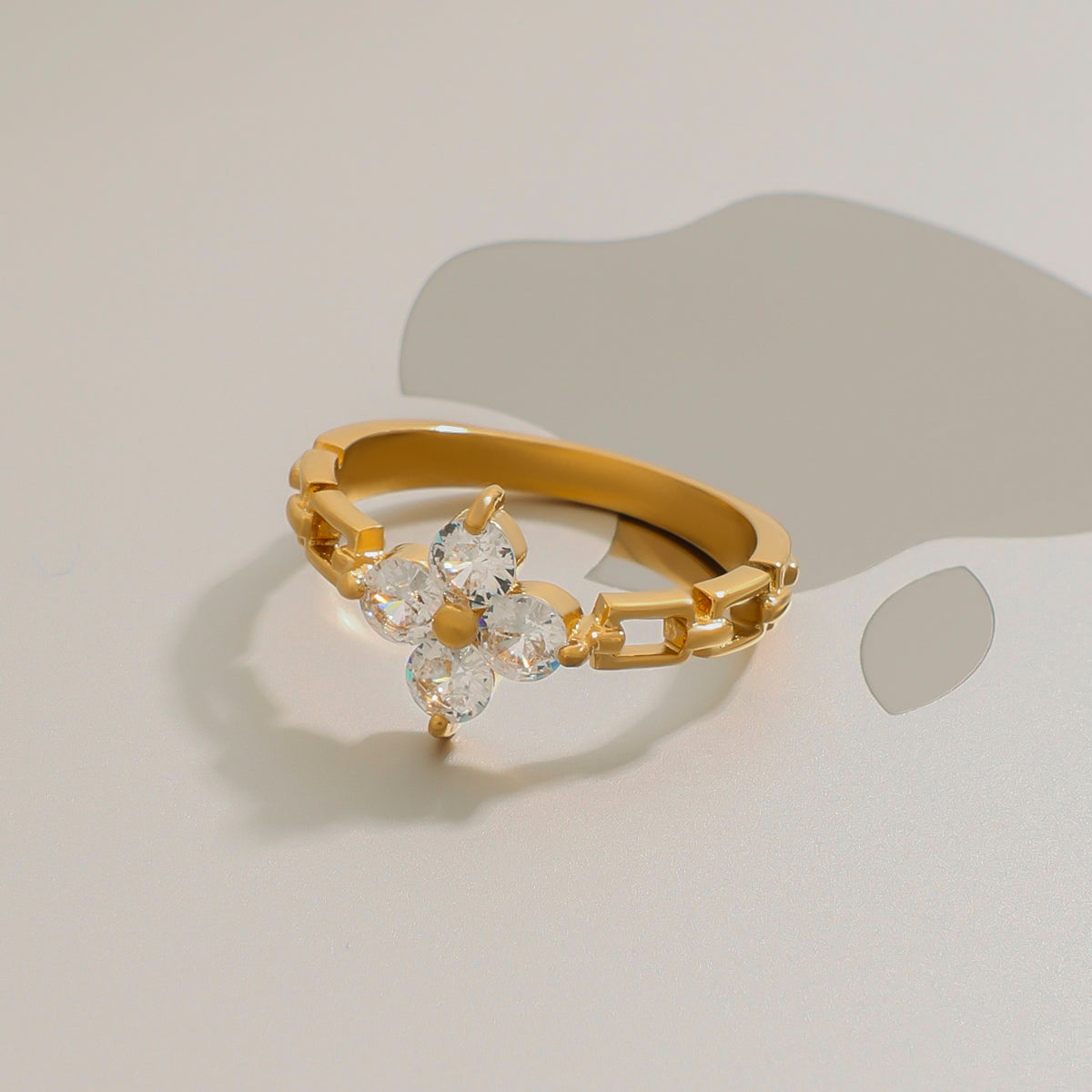 Gold ring with clear gemstones on a light background