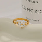 Gold ring with floral design on a Byredo Young Rose perfume bottle background