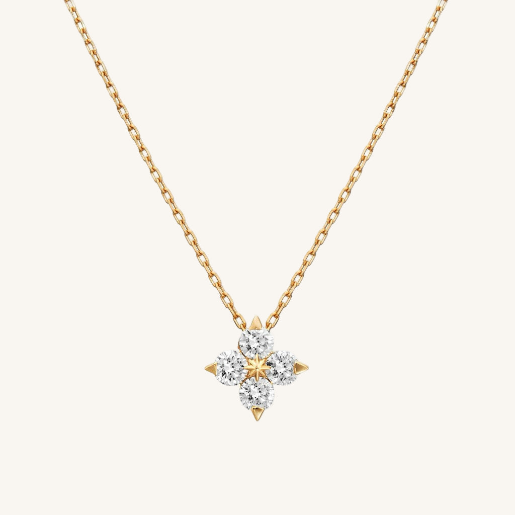 Gold necklace with a star-shaped diamond pendant on a white background