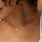 Close-up of a woman wearing a gold necklace with a small pendant.