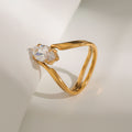 Gold ring with a clear gemstone on a light background