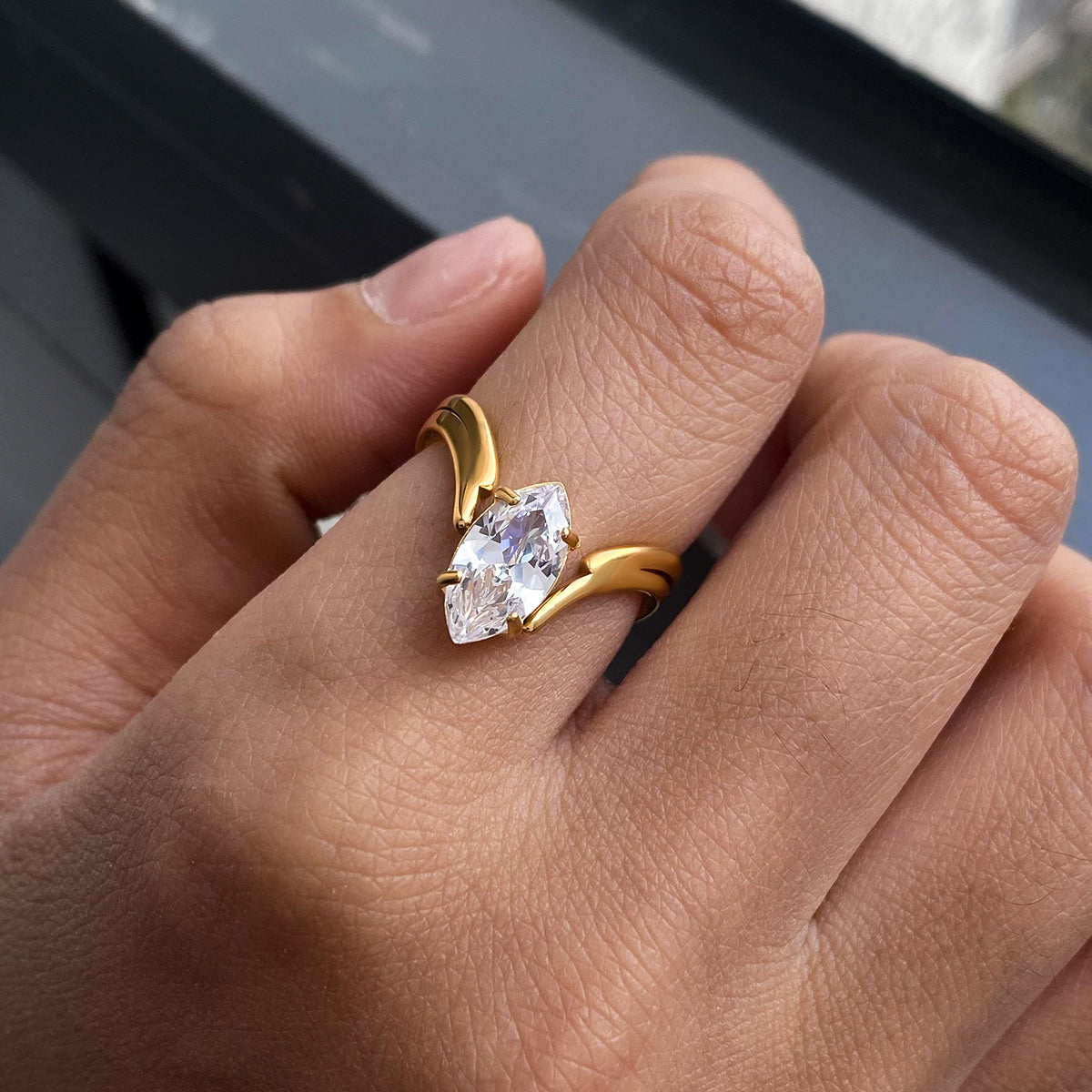 Gold ring with a heart-shaped diamond on a person's finger