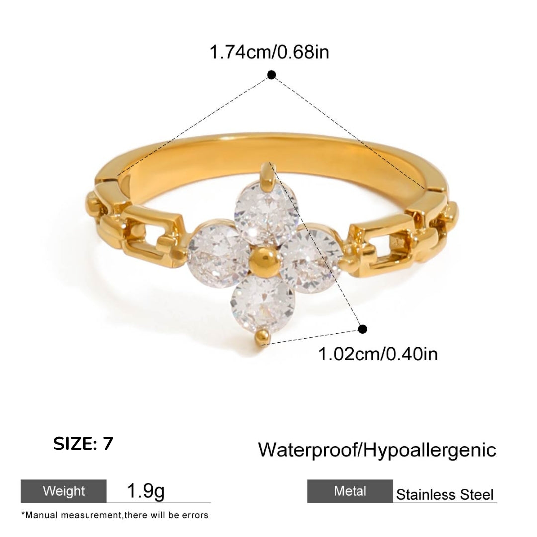 Gold ring with diamond-like stones and measurements on a white background