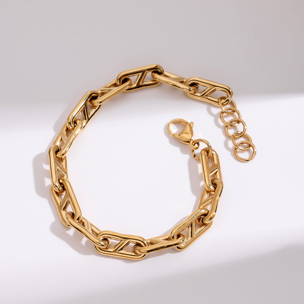 Gold chain bracelet on a light gray background