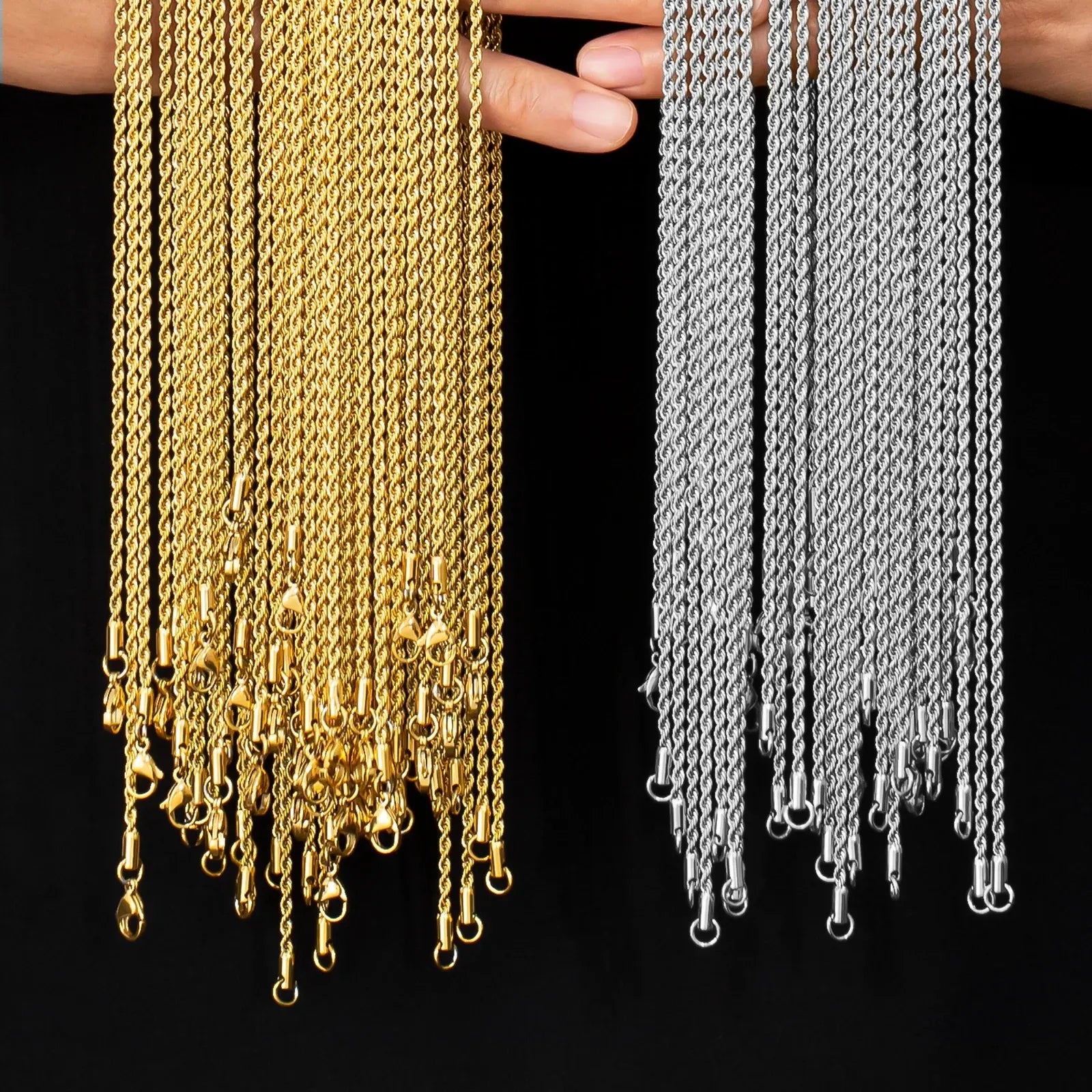 Gold and silver chains held by a person against a black background