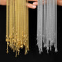 Gold and silver chains held by a person against a black background