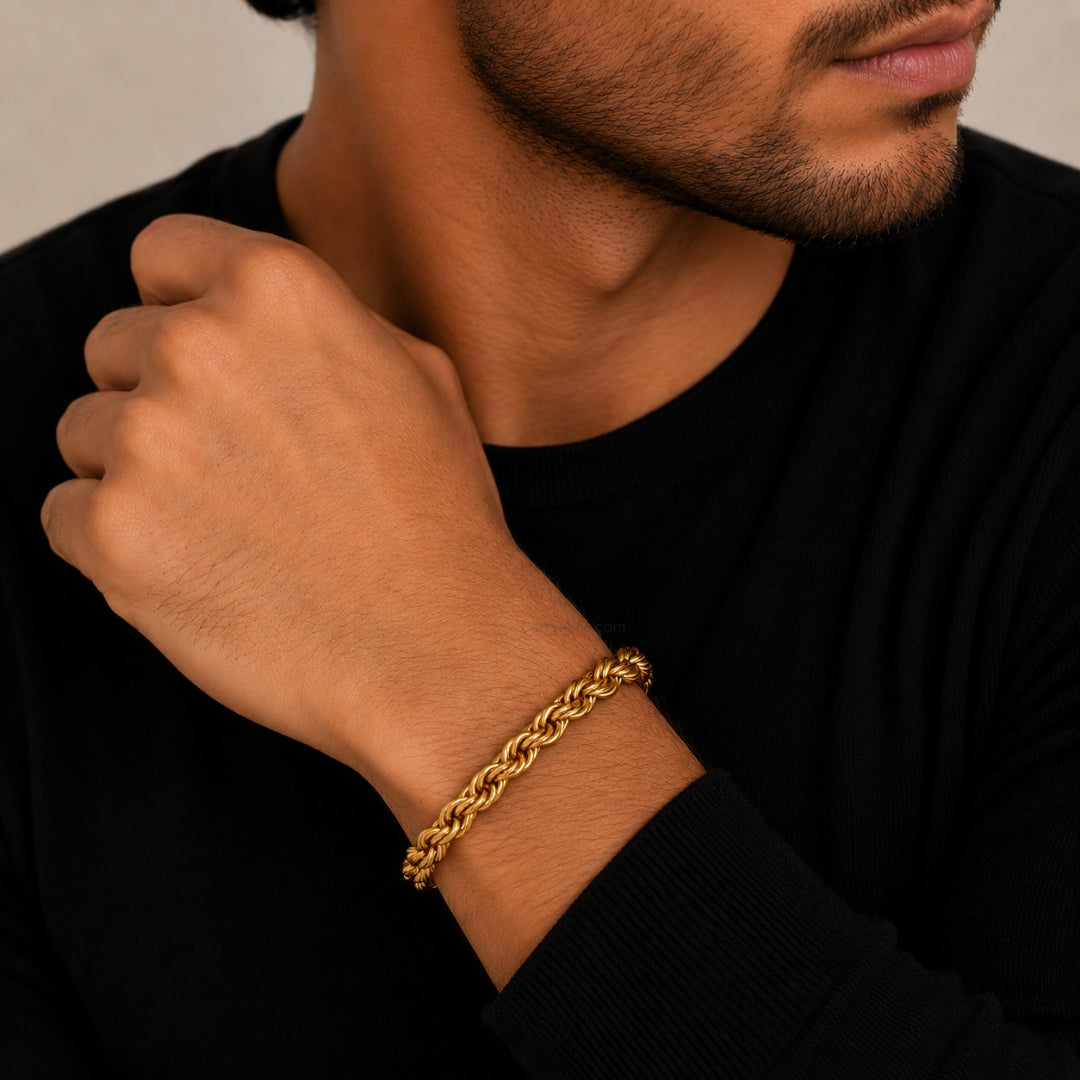 Man wearing a gold chain bracelet on a neutral background
