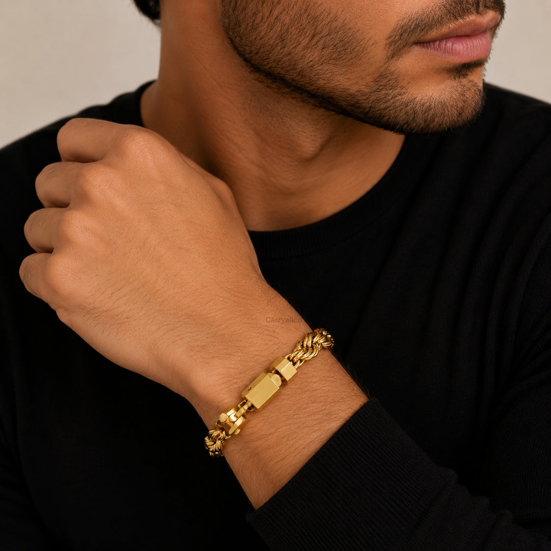Man wearing a gold bracelet on his wrist against a neutral background