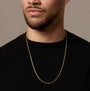 Man wearing a gold chain necklace against a neutral background