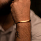 Gold bracelet on a wrist with a blurred background