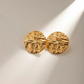 Pair of gold round earrings on a light background