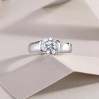 Silver ring with a diamond on a beige fabric background