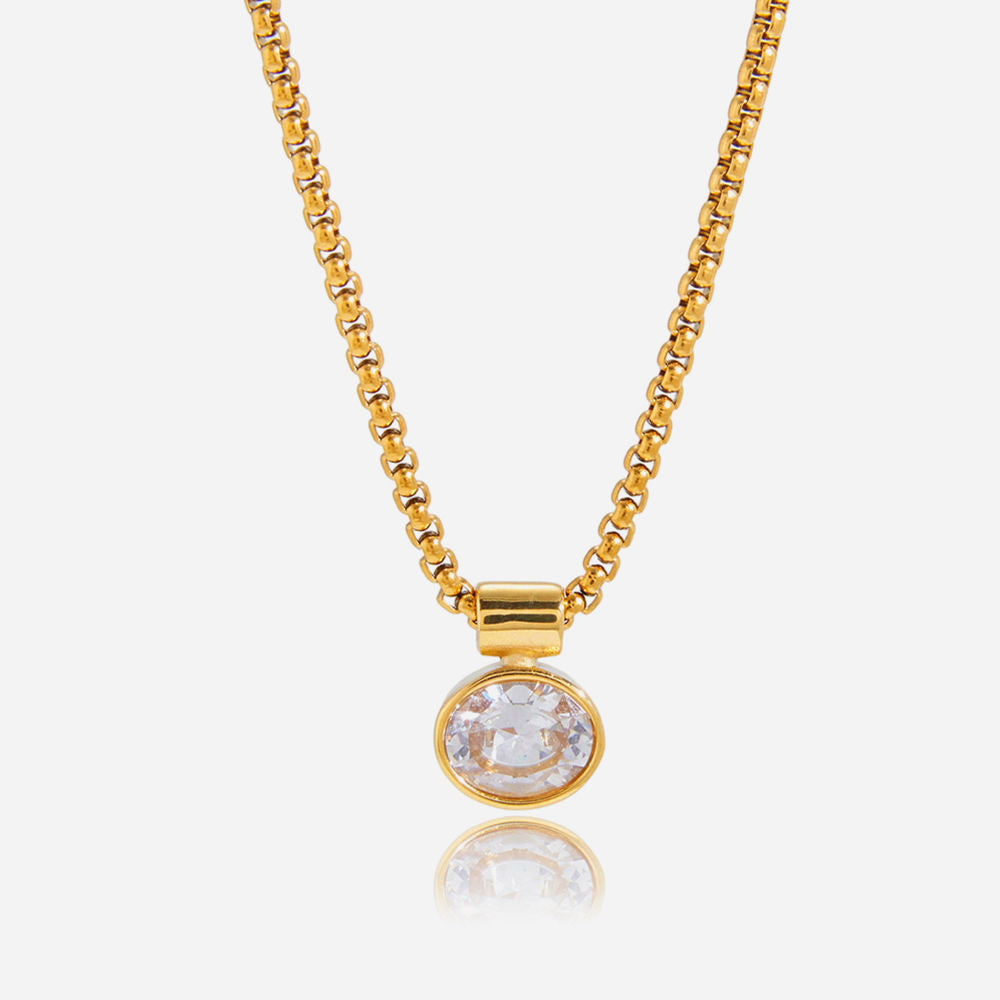 Gold necklace with a round pendant on a white background
