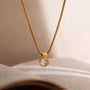 Gold necklace with a diamond pendant on an open book