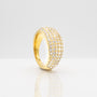 Gold ring with embedded stones on a light gray background