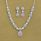 Jewelry set with necklace and earrings featuring pink stones on a brown background