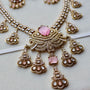 Ornate necklace with pink gemstones on a light background