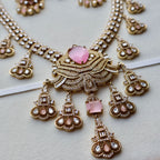 Ornate necklace with pink gemstones on a light background